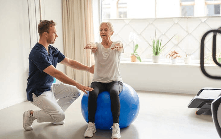 Un coach accompagne une cliente pendant un exercice dans son salon