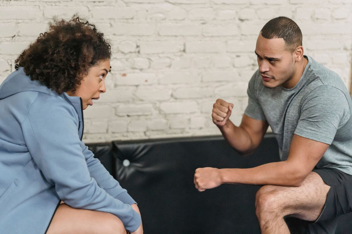 Un coach sportif discute avec son client avant de commencer la séance